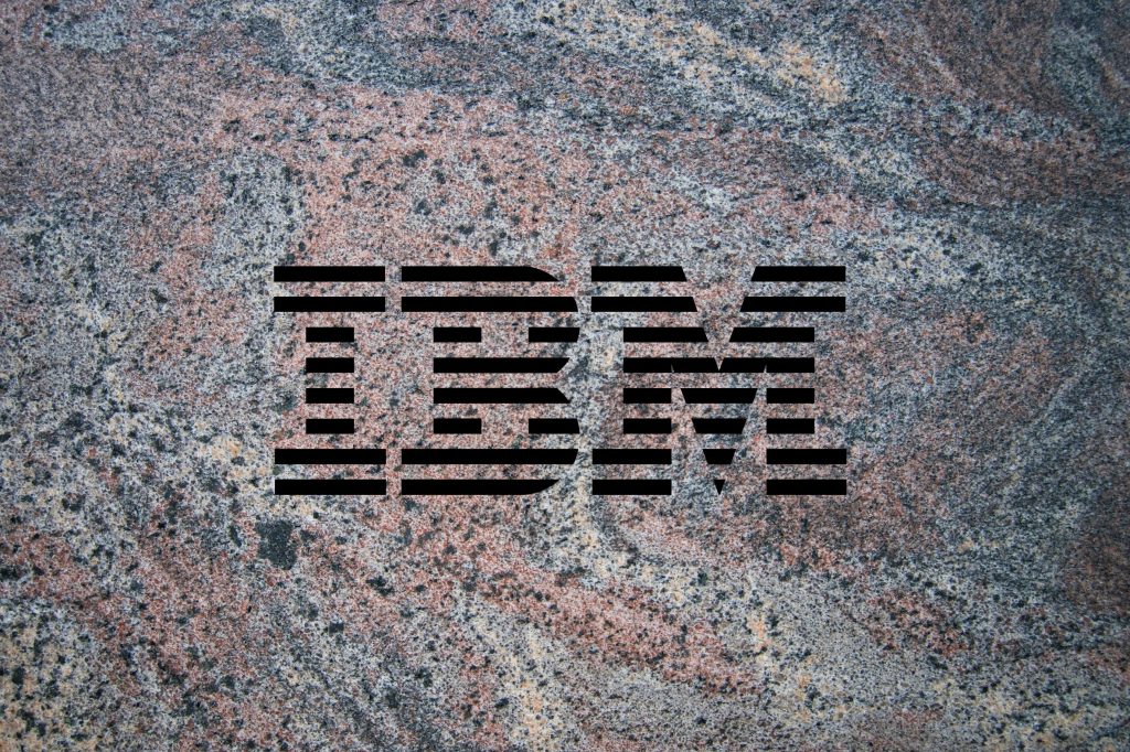 IBM logo on a granite background to illustrate the launch of the company's Granite 3.0 family of AI models alongside an open-source commitment.