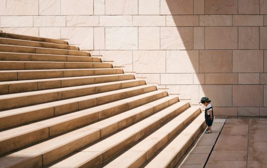 Kid facing the challenge of large stairs illustrating the diminishing returns that OpenAI is reportedly facing with the training and development of its latest AI model.