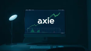 Axie Infinity logo and green price chart on a computer monitor in a dimly lit room