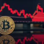 Bitcoin coin in foreground with a red declining price chart in the background, representing market downturn.